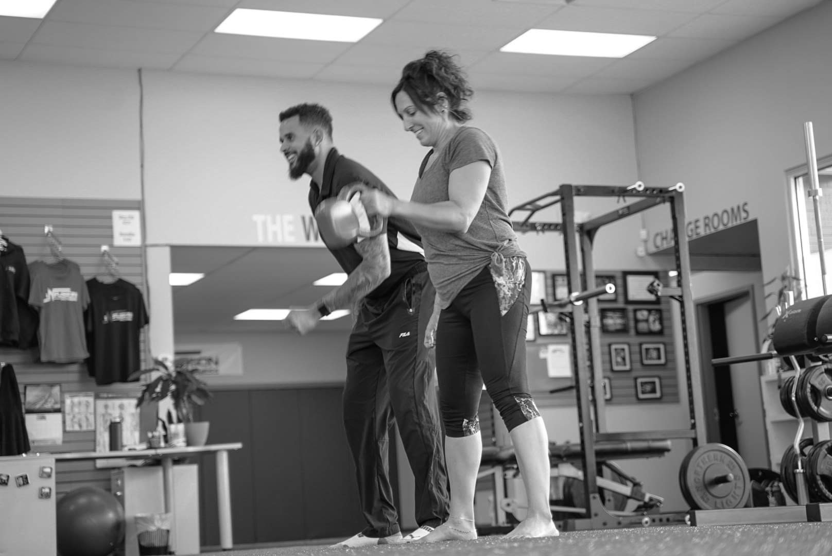 Cassidy coaching a client through a kettlebell swing in the studio